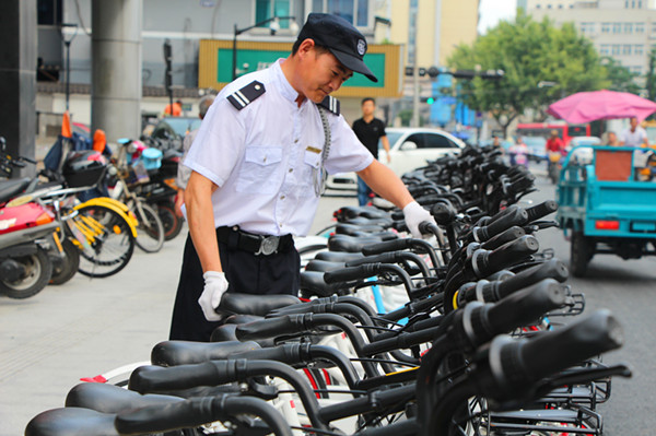 耀江物业保安正在管理共享单车